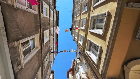 Wide shot of Laundry lines stretched between tall residential buildings in a Stock Footage 321347693