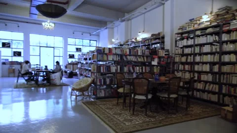 Wide shot of a library and a shared working space with two women in masks wo Stock Footage 142074174