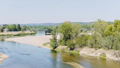 Wide shot of the Loire River flowing past sandbanks and green trees in Stock Footage 346687347