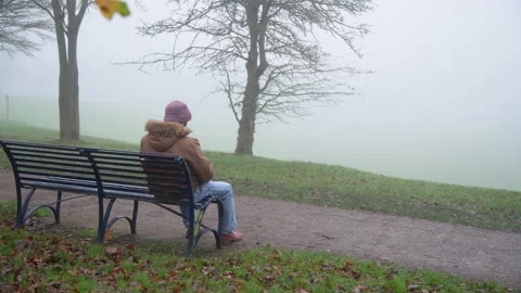 Wide Shot: Lonely Elderly Man Wearing Mask Sits Alone in Park  Stock Footage 147900752