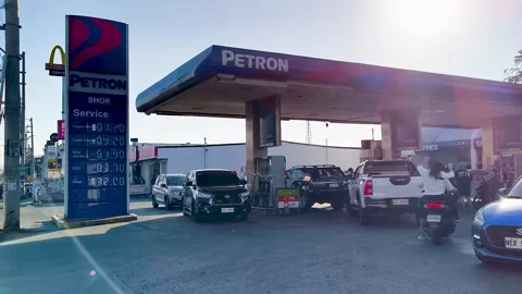 Wide shot of long line of vehicles waiting at a fuel station in the Philippines Stock Footage 332622480