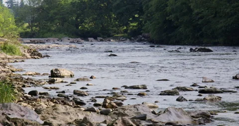 Wide shot looking up the river Lune next to the Devils bridge at Kirkby Stock Footage 328891874