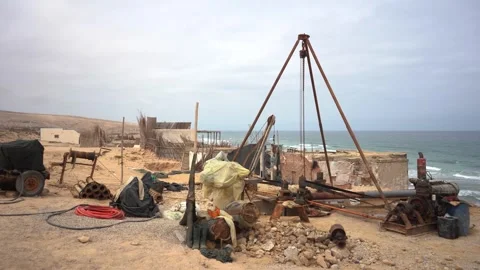 Wide Shot of Makeshift Drilling Rig in Remote Coastal Village with Engine Audio Vídeos de archivo 334182533