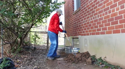 A wide shot of a man installing a window well Stock Footage 45431887