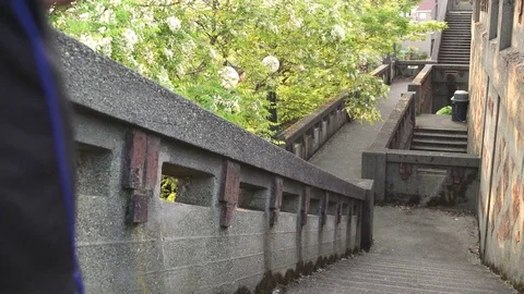 Wide shot of man running down on stairs 動画素材 76236635