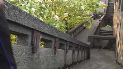 Wide shot of man running down on stairs 動画素材 76541120