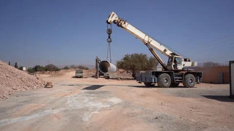 Wide Shot of Mobile Crane Hoisting Large Pipe at Pipeline Construction Site Vídeos de archivo 334948176