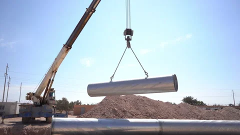 Wide Shot of Mobile Crane Lifting Large Metal Pipe at Pipeline Construction Site Vídeos de archivo 334940624