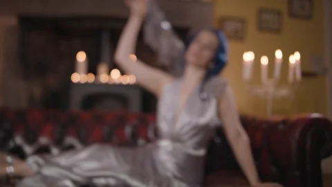 Wide shot of model taking of shawl on sofa seductively Stock Footage 109488612