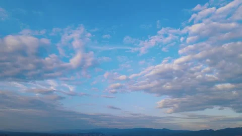 Wide Shot of Mountain Skyline Under Blue Skies With Fluffy White Clouds 動画素材 342236670