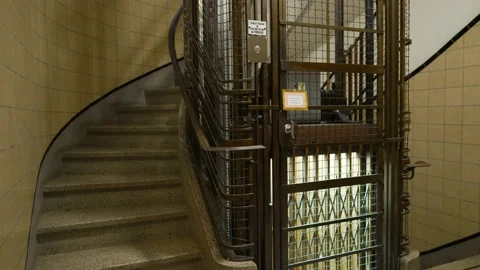 Wide shot of an old vintage elevator going up and arriving empty at the Stockbeeldmateriaal 150574427