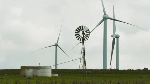 Wide shot of old windmill against idle modern wind turbines. Stock Footage 87849011