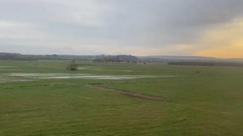 Wide shot out of a window of train, tracking along flat British UK southern  動画素材 170464675