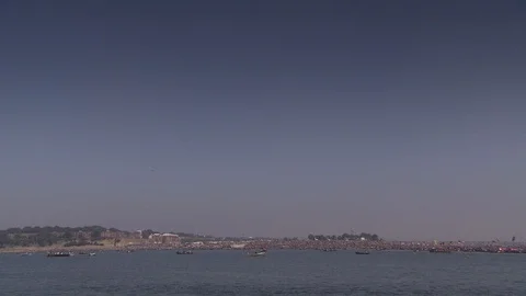 Wide shot pan across Ganges River during Kumbh Mela pilgrimage Stock Footage 86760670