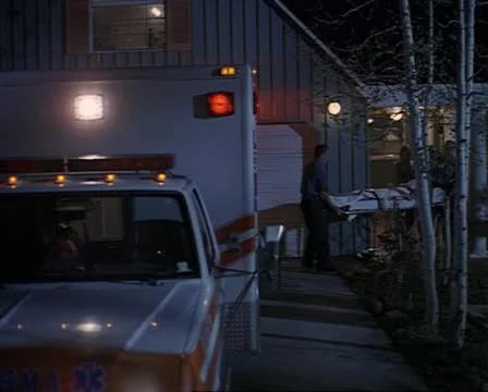Wide shot as paramedics wheel a gurney out of a house and into a parked Stock Footage