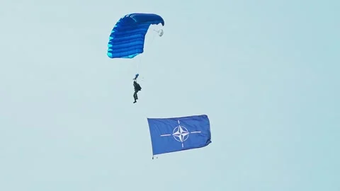 Wide shot of Paratrooper skydiving with big NATO flag Stock-Footage 337202987