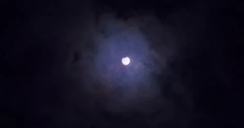 Wide shot of a partial solar eclipse. Clouds moving in front of the sun. Stock Footage 155476838