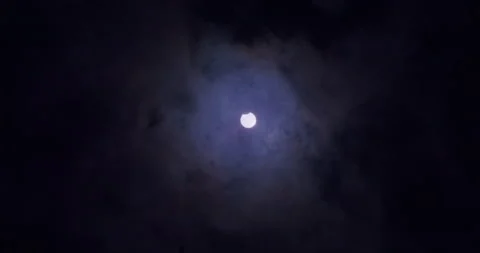 Wide shot of a partial solar eclipse. Clouds moving in front of the Stock Footage 155486304