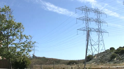 Wide Shot of Power Lines &amp; Tower with Field Below Stock Footage 4279833