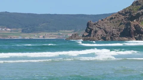 Wide shot of Praia do Rostro beach in Spain, showing turquoise waves breaking on Stock Footage 346711724