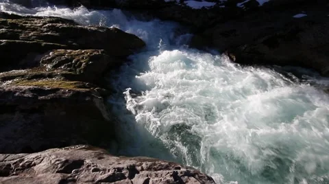 Wide shot of raging waterfall between frozen rocks Stock Footage 40012840