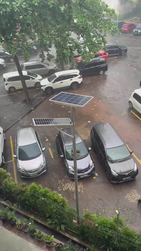 Wide Shot of Rain Falling on Solar Panels in Hospital Parking Lot Vidéo 309031676