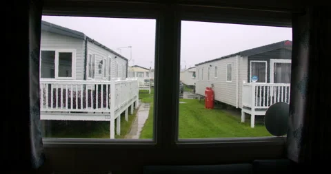 Wide Shot of rain on a static caravan window with static caravans in background Stock Footage 346814536