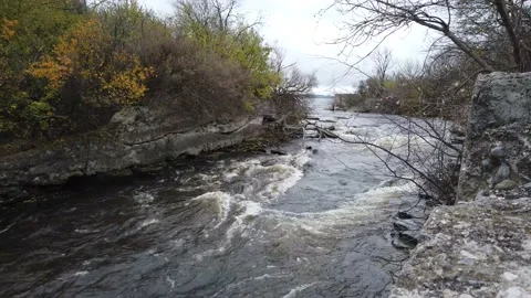 Wide shot of a river flowing between two rocky shores Stock Footage 143197885