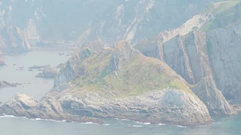 Wide shot of rugged rocky cliffs and coastal landscape along the shoreline near Stock Footage 346716048