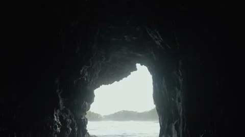 Wide shot of a sea cave opens to the ocean and distant land. Stock Footage 312839081