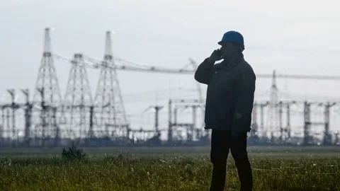 Wide shot of serious supervisor in hard hat talking on a smartphone during an Stock Footage 75631316