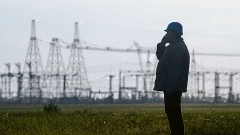 Wide shot of serious supervisor in hard hat talking on a smartphone during an Stock Footage 75631546