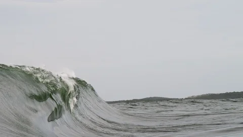 Wide shot from the side of a heavy wave breaking in slow motion and Stock Footage 127444138