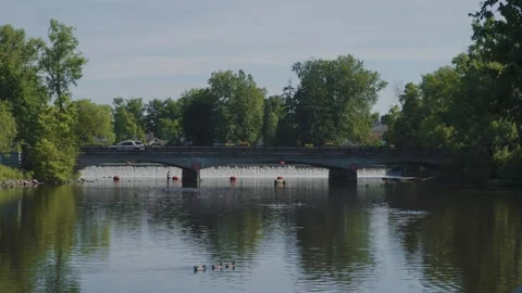 Wide shot of a small bridge and dam on a sunny day Stockbeeldmateriaal 337889524