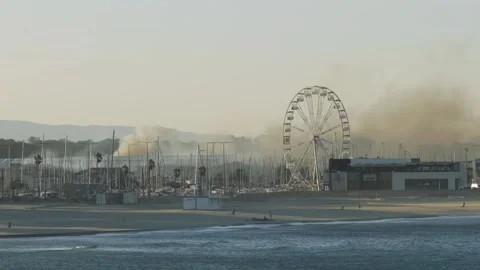 Wide shot of smoke rising from a fire near Camping Brasilia in Canet-en Stock Footage 346666441