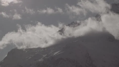 Wide Shot Snowy Mountain Range Dark Clouds Passing Peaks Purple Twilight Stock Footage 329240181