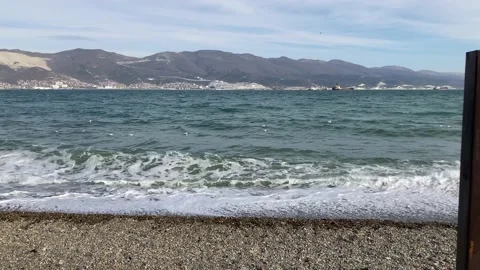 Wide shot of stormy waves with a mountain in the background Stock Footage 148708080