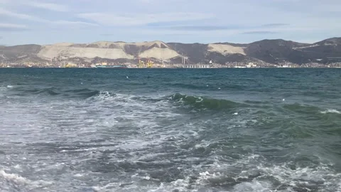 Wide shot of stormy waves with a mountain in the background Stock Footage 148708178