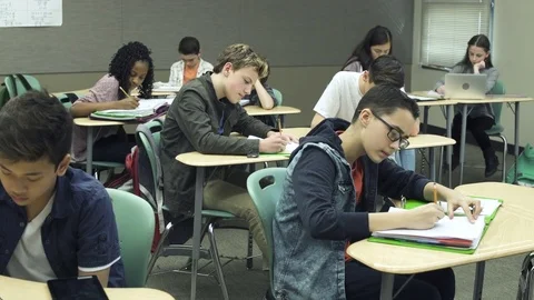 Wide shot of students writing in classroom 動画素材 76536602