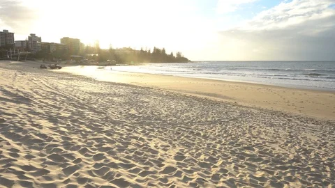 Wide shot of sun light gently touching a soft sandy beach waves hitting Stock Footage 111832470