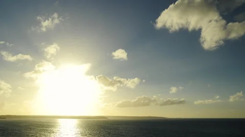 Wide shot of a sunset in timelapse over ocean and cliffs. Progressive zoom. Stock Footage 68796253