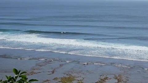 Wide Shot of Surfers Catching Waves at Uluwatu Beach, Bali Stock Footage 340322537
