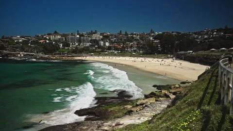A wide shot of Sydneys Bronte Beach on a summer day, featuring rolling ocean Stock Footage 306124408