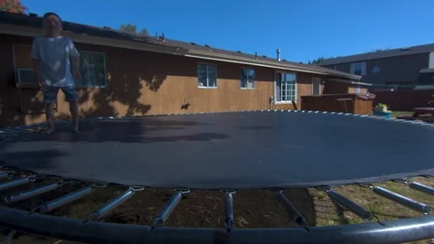Wide Shot of Two Boys Jumping on a Trampoline in Slow Motion Stock Footage 94872025