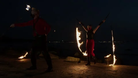 Wide shot of two fire artists performing their show Stock Footage 144743900