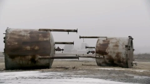 Wide Shot of Two Large Water containers junked in farm field winter fog Stock Footage 89945129