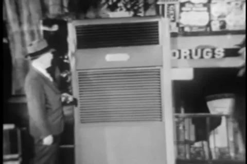Wide shot of two men checking out old fashioned air conditioner, 1950s Stock Footage 35328050