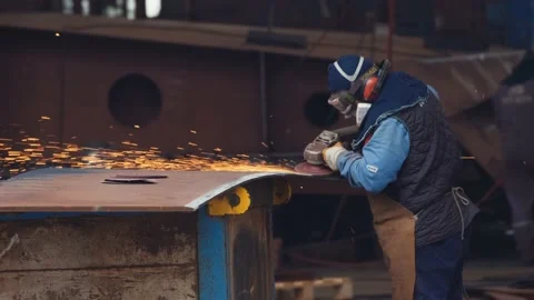 Wide shot of unrecognizable shipyard worker wearing helmet, welding new Stock Footage 219457781