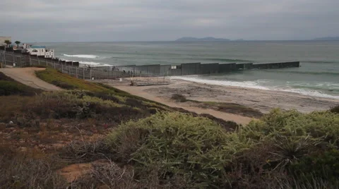 Wide shot of the US Mexico Border fence where it heads into the Pacific Stock-Footage 49792819