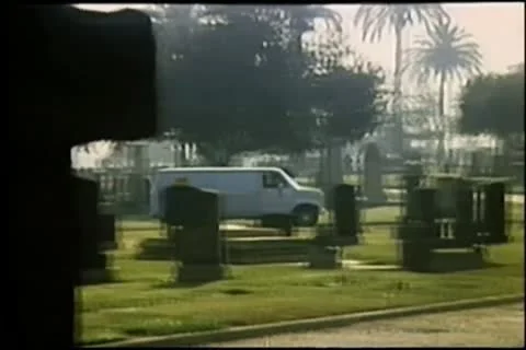 Wide shot van driving through cemetery Stock Footage 11350610